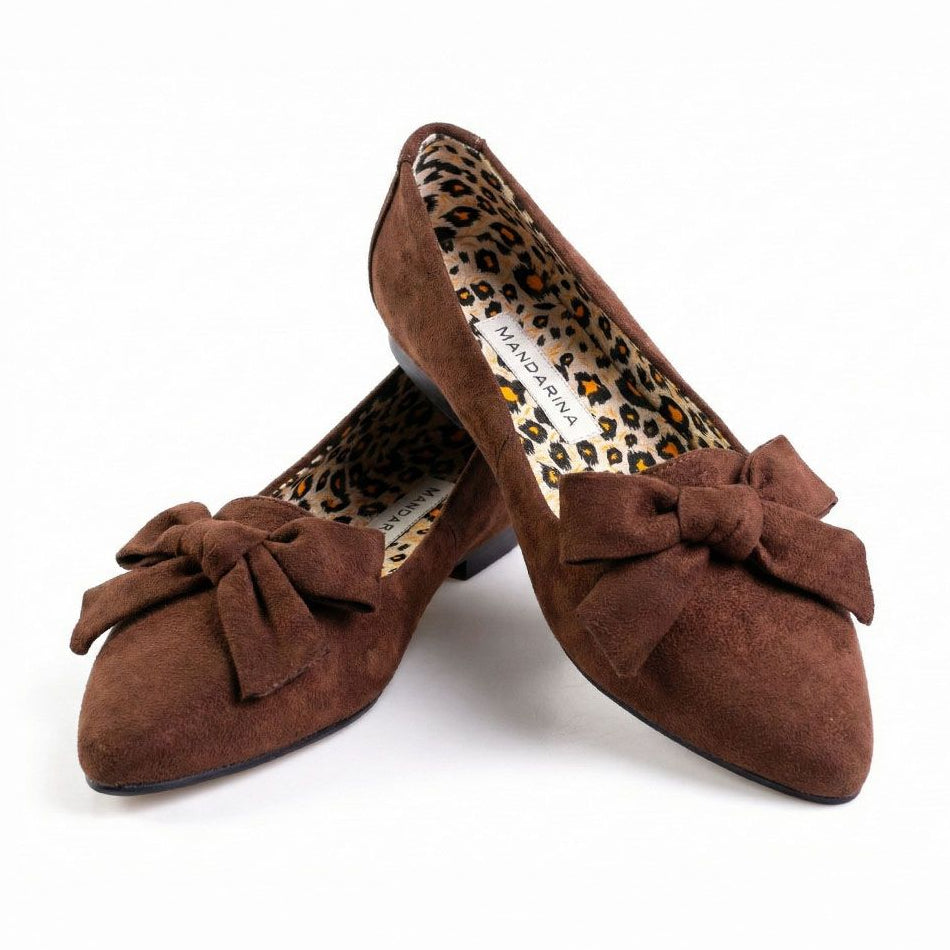 Brown suede shoes with bows on a white background