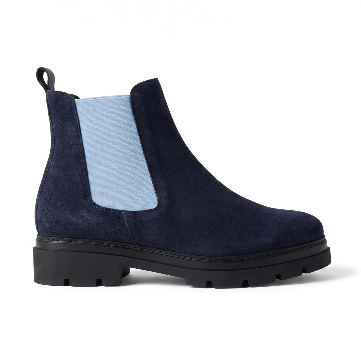 A navy blue suede Chelsea boot with a light blue elastic side panel and a chunky black sole, shown from a side profile on a white background.