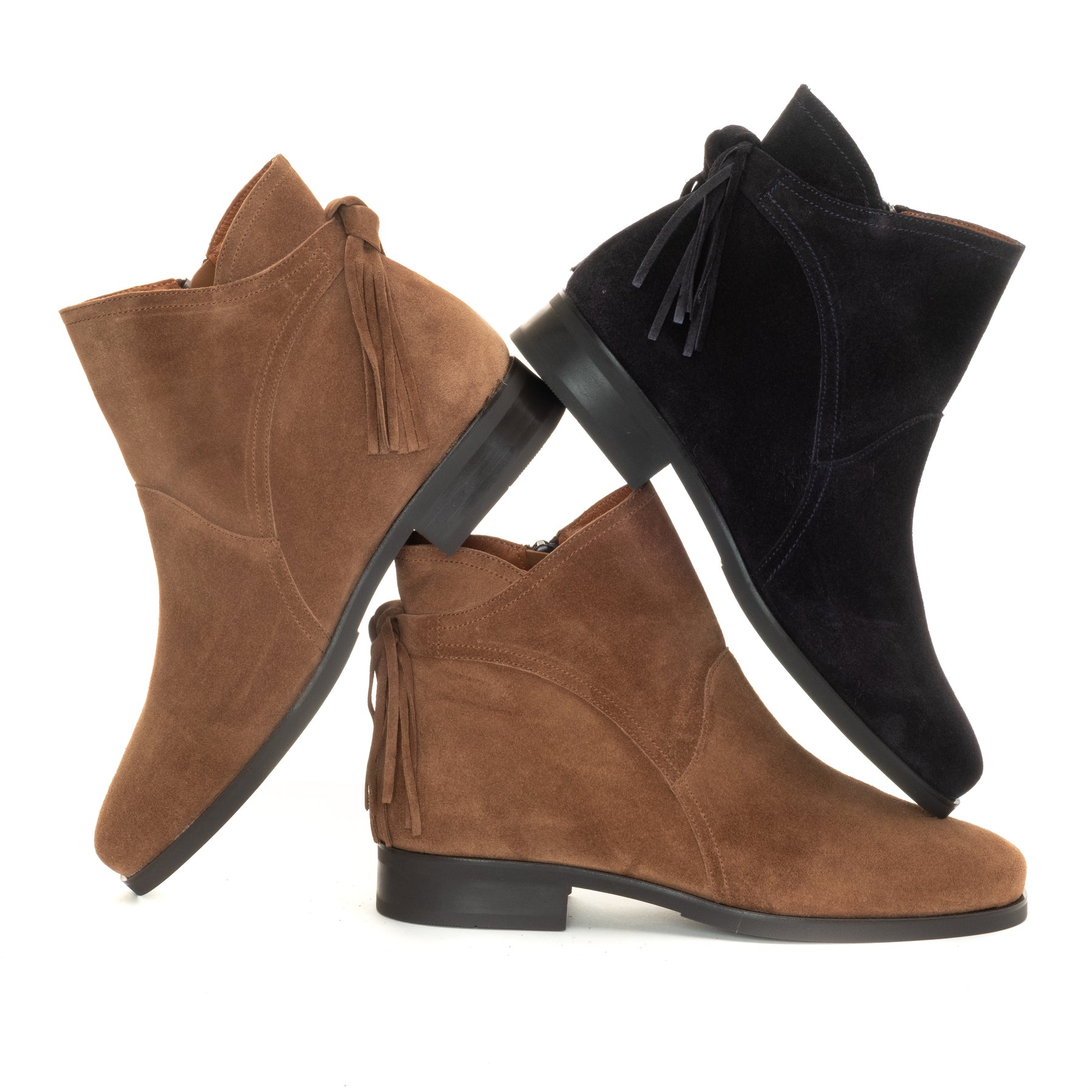 Three ankle boots made of suede and faux suede material, shown from different angles on a white background. Two boots are brown and one is black.