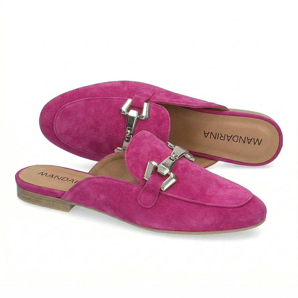 Pair of pink suede mules with silver buckles on a white background
